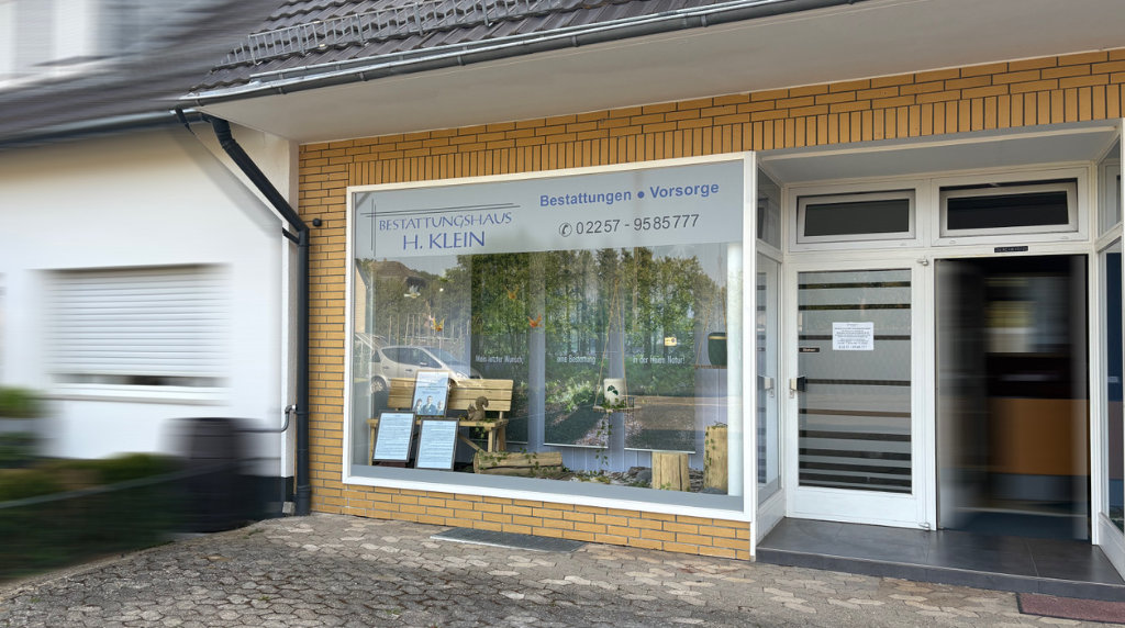 Bestattungshaus mit Schaufenster in Blau und gelbem Ziegelbau